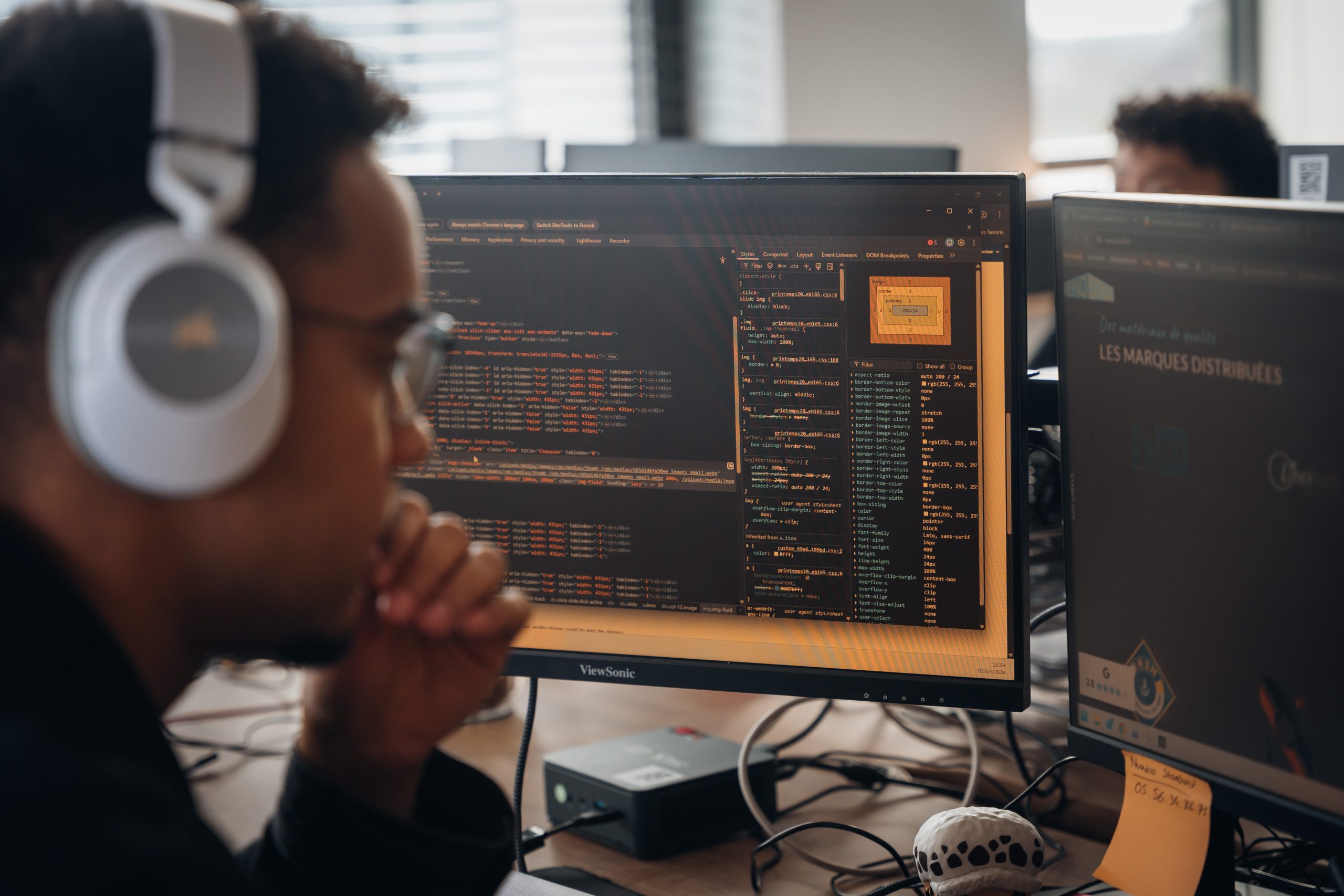 Développeur Vistalid travaillant sur le code d’un site devant deux écrans
