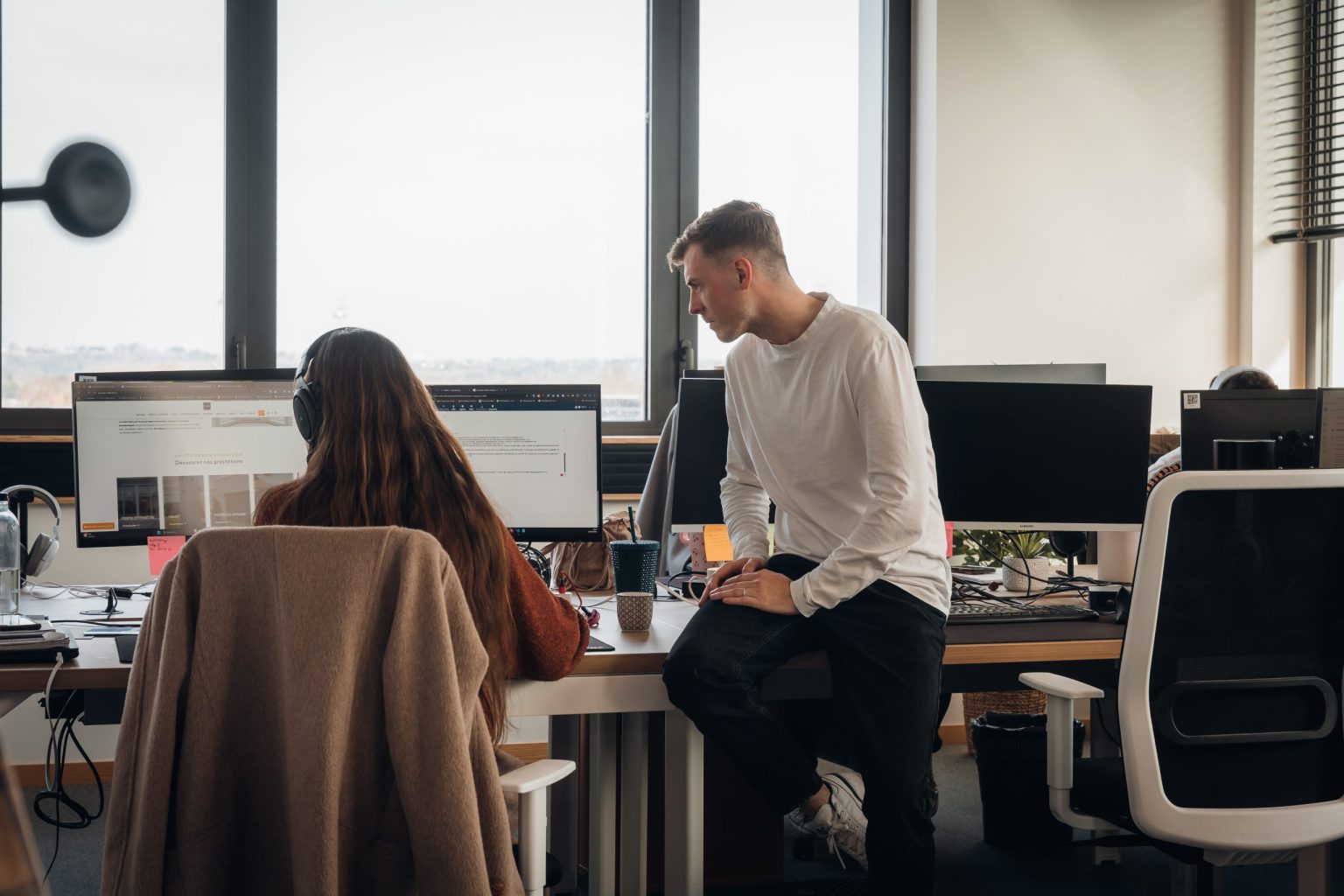 Deux collaborateurs Vistalid échangent devant un écran dans les bureaux de l’agence