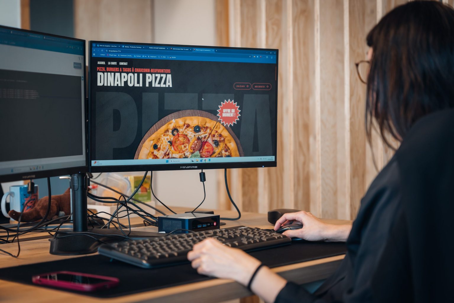 Collaboratrice Vistalid consultant le site d’un client restaurateur sur deux écrans