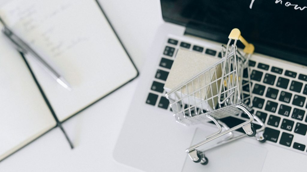 Chariot miniature posé sur un clavier, symbole de la vente en ligne